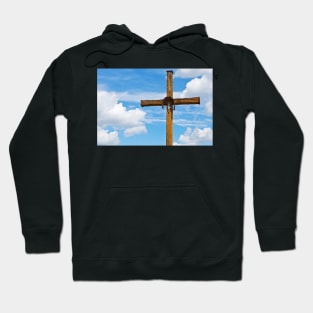 Figurine of Jesus Christ on a wooden cross against under blue cloudy sky Hoodie